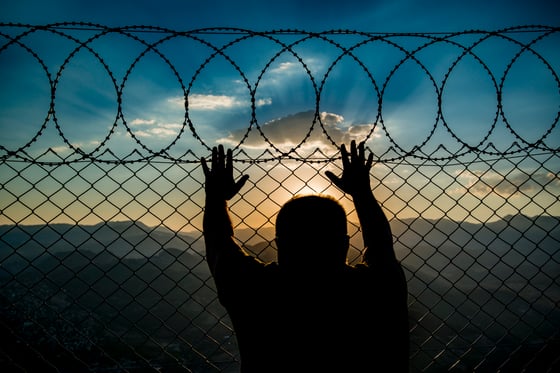 Person standing against fence